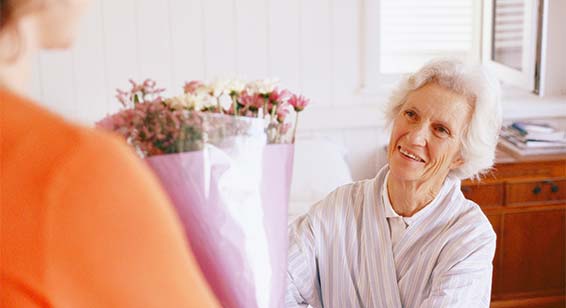 old-woman-accepting-flowers-from-a-delivery-person-errand-runner-service-for-seniors | The Personal Helpers