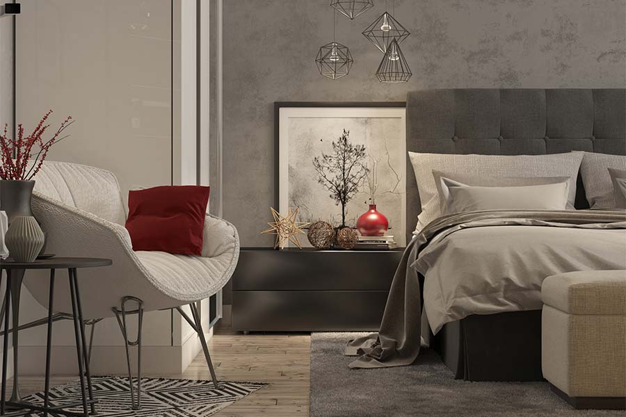 beautiful-grey-styled-bedroom-with-chair-bed-end-table-red-accents-bronze-accessories-artwork