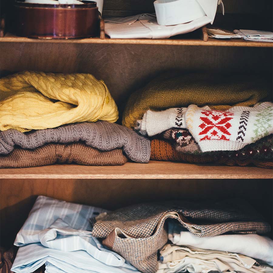 cluttered-closet-shelving-with-sweaters-and-shirts