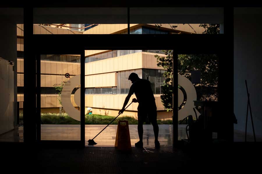 person-cleaning-office-building-entrance-with-mop-low-light-silhouette