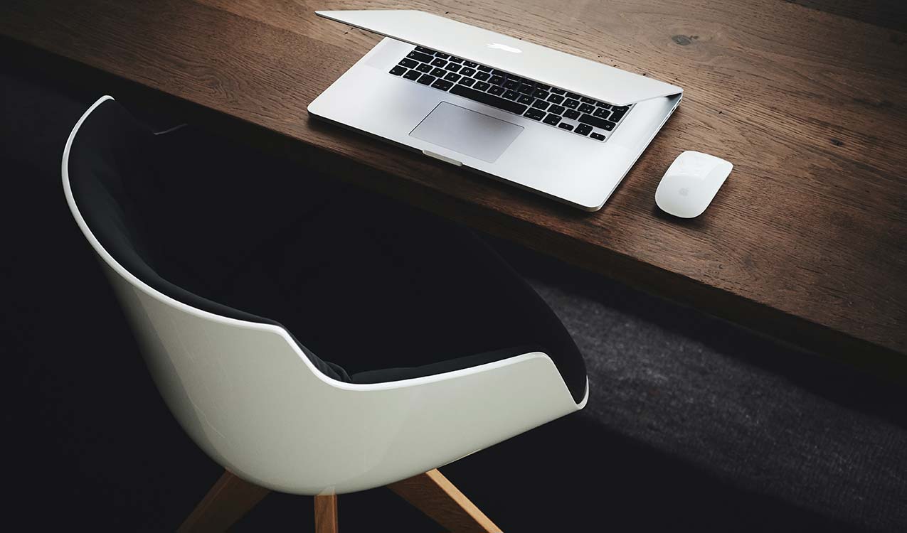 uncluttered-workspace-minimalist-modern-white-black-chair-macbook | The Personal Helpers