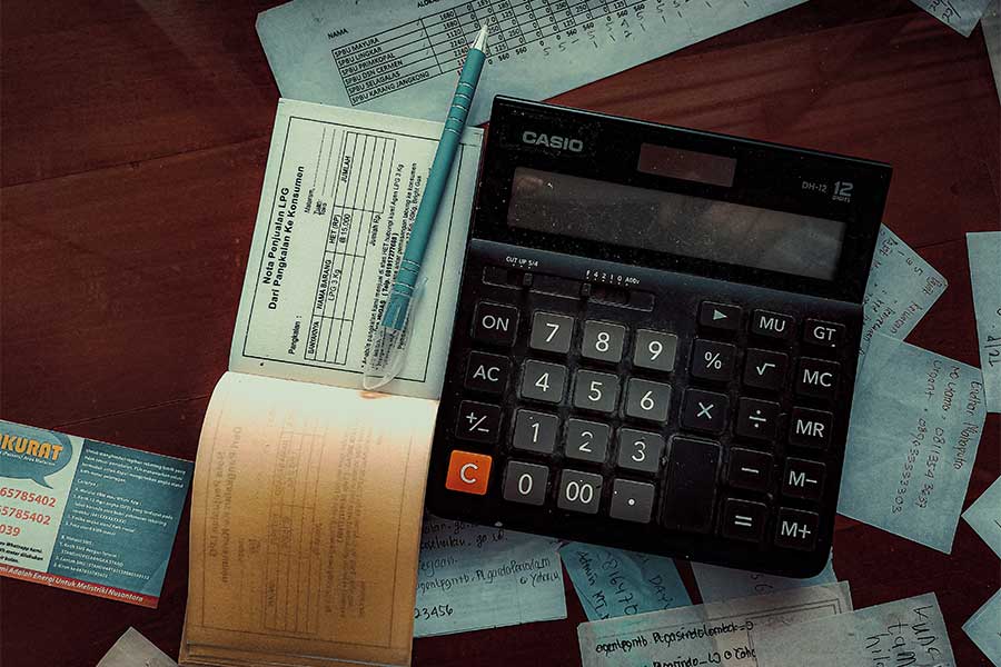 cluttered-table-crowded-by-paper-receipts-business-cards-and-calculator-for-bills