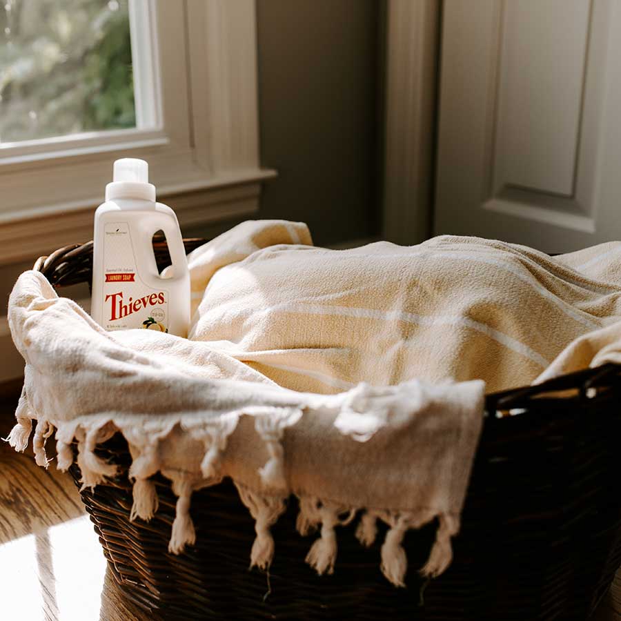 laundry-detergent-nested-in-brown-basket-off-white-throw-blanket-covering