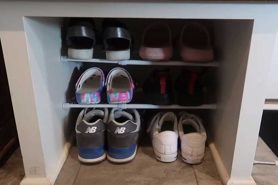 Shoes organized neatly in a cubby using tension rods