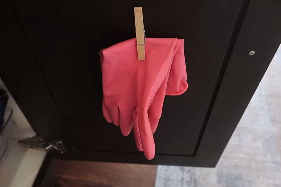 Gloves hanging on a wall with clothespins and easy tape for quick access and drying