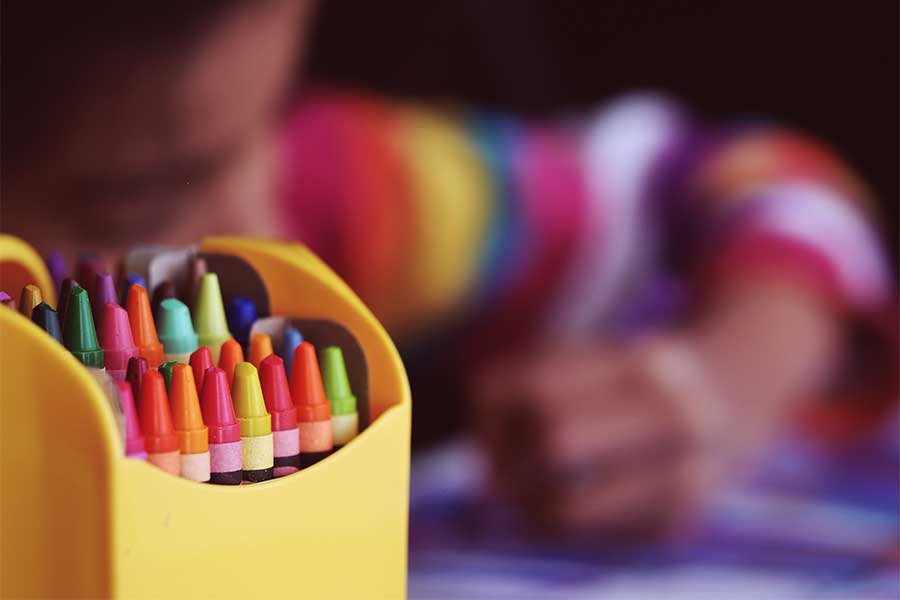 organized-crayons-while-child-draws-in-the-background