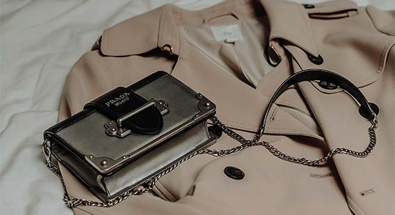 Handbag and clothing displayed on bed ready to wear